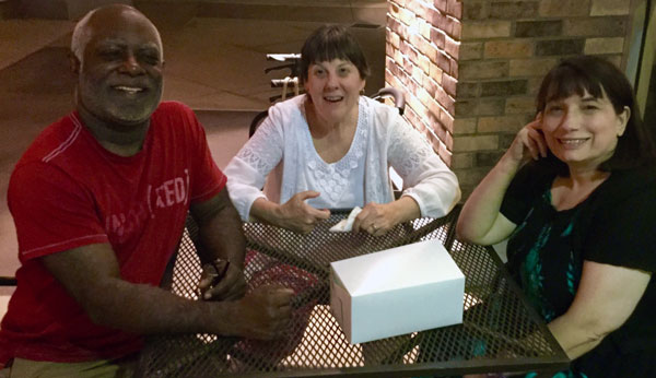 Derrick, Darian, and Jenny sitting at an outdoor table.